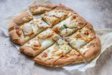 Rome pizza with white chicken meat or turkey and cheese, concrete background. Pinsa. Traditional roman pizza with chicken.
