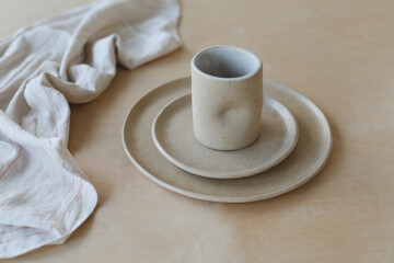 ceramic cup and plates on a wooden table top view. minimalist set of handmade ceramic tableware and pottery