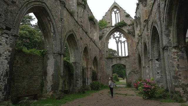 A young woman visiting the ruins of the Abbaye de Beauport church in the village of Paimpol, Ctes-d'Armor department, French Brittany. France