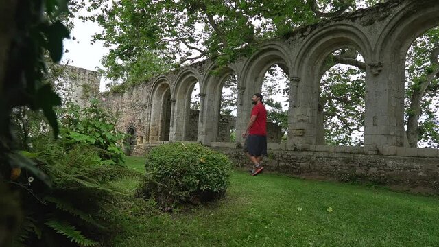 A young man visiting the interior gardens of the Abbaye de Beauport in the village of Paimpol, Ctes-d'Armor department, French Brittany. France