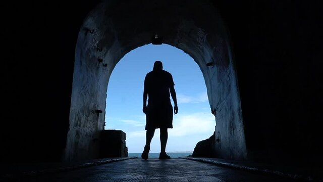 A young man in the tunnel to the sea at the Fort des Capucins a rocky islet located in the Atlantic Ocean, Roscanvel, on the Crozon peninsula in France.