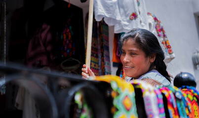 Beautiful Mexican merchant selling in store specializing in embroidery clothing, artisan merchant...
