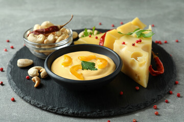 Fototapeta na wymiar Tray with cheese sauce and ingredients on gray textured table