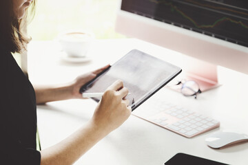 New normal, self-employed women hand holding pen are using tablet and computer laptop to trade stocks for profit, buying and selling.