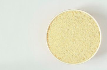 Fototapeta na wymiar An image top view cut out or isolated rice grain in the bowl is food uncooked raw with nutrients carbohydrate on white background with copy space for text.