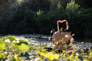 Fototapeta premium ragazza che suona l'ukulele in spaiggia al fiume