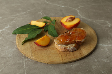 Sandwich with peach jam and ingredients on gray textured table