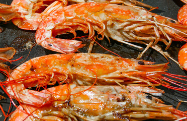 Cocinando deliciosas gambas a la plancha con aceite de oliva. Primer plano de los deliciosos...