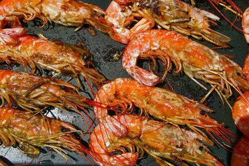 Cocinando deliciosas gambas a la plancha con aceite de oliva. Primer plano de los deliciosos mariscos durante el proceso de cocción.