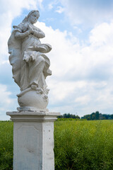 An old sculpture in the field depicting an angel.
