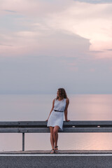 woman in white dress sunset above the sea