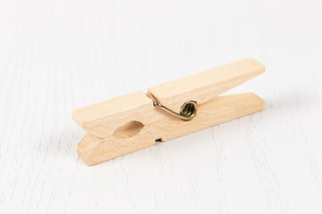 wooden clothespin with metal spring on the background of a white wooden table. close-up. selective focus