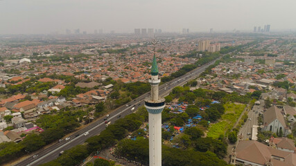 aerial view minaret mosque Al Akbar against city Surabaya highway, skyscrapers, buildings and houses. mosque in Indonesia Al Akbar in Surabaya, Indonesia. beautiful mosque with minarets on island Java