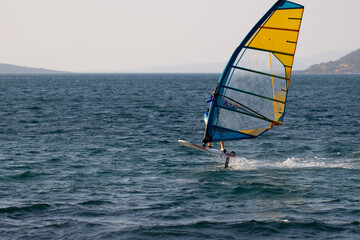 Windsurfing, extreme sports. Water sports. Athlete in competition. Seascape with athlete. High quality photo