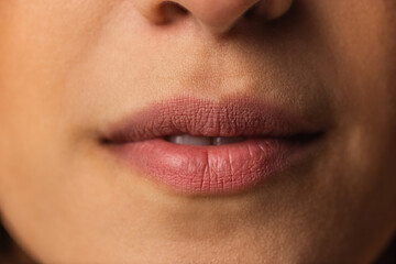 Close-up female lips with nude makeup. Concept of natural beauty, cosmetics, anti age treatment, wellness