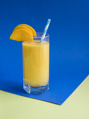 Mango smoothie in a glass ona blue background . Mango smoothie concept . Food concept
