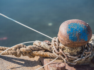Fototapeta premium Bollard (Bollard known in nautical language) with sailor's knot and chains in the port