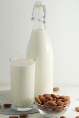 A glass with almond milk and the bowl with almonds	