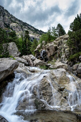small waterfall in a high mountain river running between rocks, river Noguera de Tor, Cavallers reservoir, in the Boi Valley, in the Pyrenees of Lleida, Spain