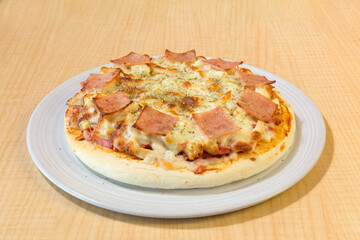 Italian pizza in white plate on wooden table