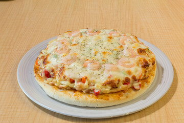 Italian pizza in white plate on wooden table