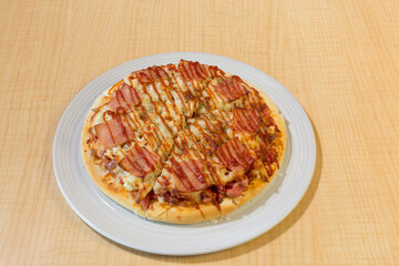 Italian pizza in white plate on wooden table