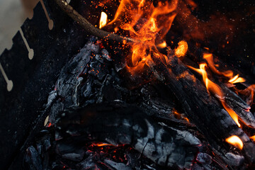 Defocused closeup photography of burning flame with sparkles.Burning bonfire. A picnic concept in nature.Selective focus.Blurred background.