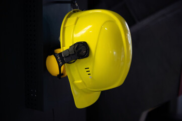 Yellow protective helmet of a metallurgical plant worker on a dark background. Construction site safety concept.
