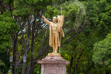 Estatua de Miguel Hidalgo de color oro en el centro del parque La Alameda en la ciudad de Querétaro, México.