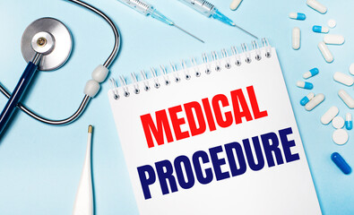 On a light blue background, an electronic thermometer, a stethoscope, white and blue pills, syringes and a notebook with the text MEDICAL PROCEDURE. Medical concept