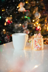 Christmas card hot cocoa with marshmallows on the background of the Christmas tree