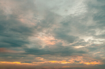 Obraz premium The sun shines through the clouds in the sunset sky with dramatic light. The shape of the clouds evokes imagination and creativity. They can be used as wallpapers that look amazing. Copy space.