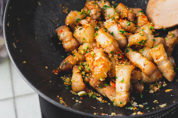 Stir fried pork belly slice with chili and salt in a black pan. Deliciousness of asian food. Thailand street food.