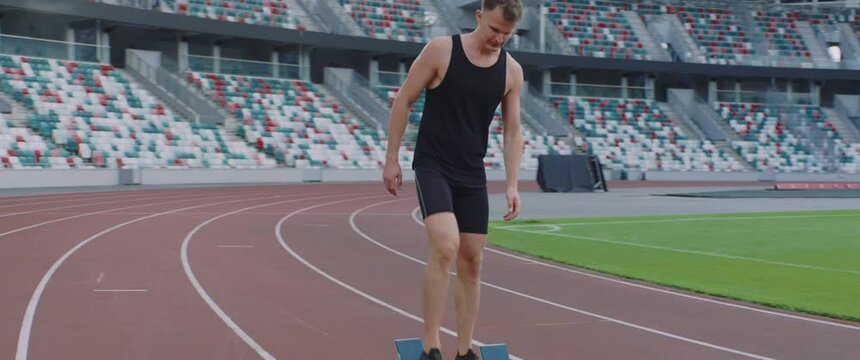 TRACKING Caucasian professional athlete practicing running on a large stadium. Shot with ARRI Alexa Mini with 2x anamorphic lens