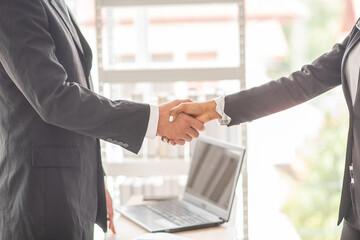 Business man shake hands with business women agreeing on partnerships or introducing themselves for...