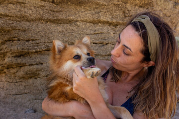 Blonde woman with headband in nature playing with her dog. Selective focus. Copy space.