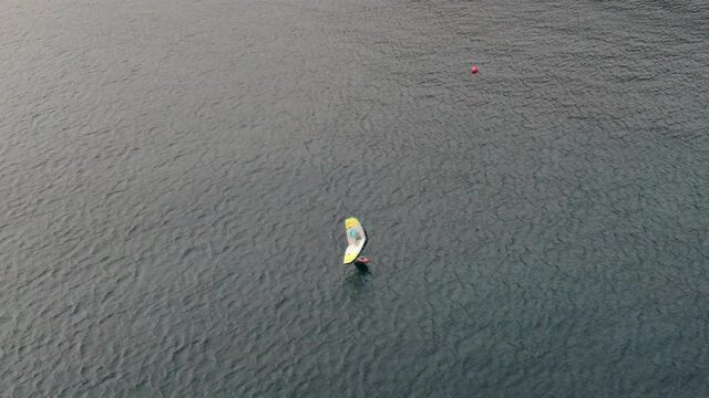 drone shot of man doing windsurfing in the sea. Gran Canaria Island.