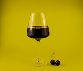 a glass of red wine with cherries