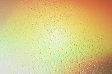 waterdrop texture over abstratc rainbow background. warm water surface backdrop