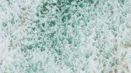 Fototapeta premium Top view or aerial view of Beautiful crystal clear water and white beach.Beautiful Landscape views famous beach waves and sea background. 
