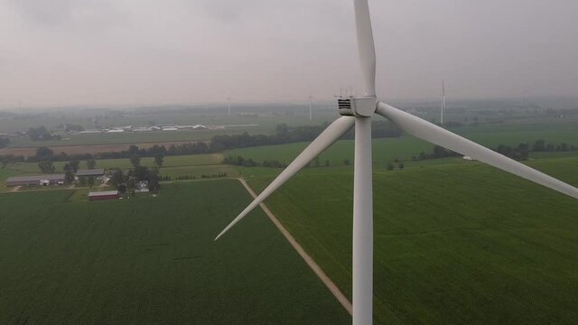 Windmill Turning At DTE Wind Farm With A View Of Vast Green Meadow In Ithaca, Gratiot County, Michigan. static shot