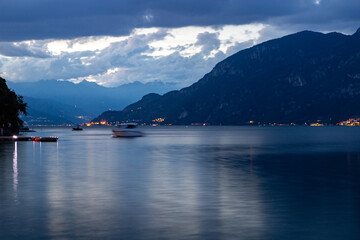 Fototapeta na wymiar Night view of Lake Como and the cloudy mountains of Vasenna