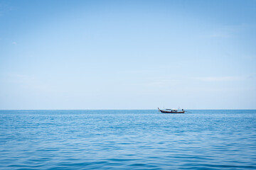 ship in the sea. Long tail boat on the white beach.smooth waves and beautiful cloud in sky.