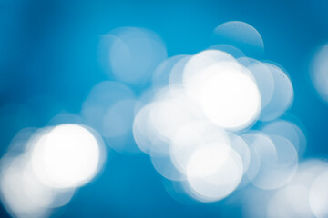 Soft focus bokeh light effects over a rippled,Lights on sea waves background.