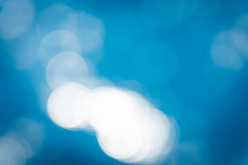 Soft focus bokeh light effects over a rippled,Lights on sea waves background.