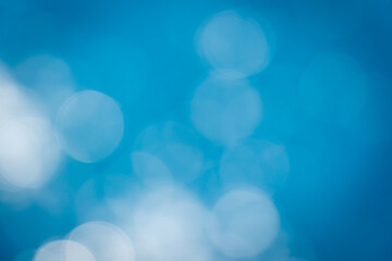 Soft focus bokeh light effects over a rippled,Lights on sea waves background.