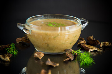 hot homemade vegetable vegetarian soup with dried mushrooms in a glass bowl