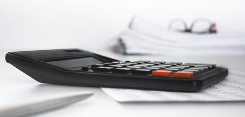 Stack of documents , calculator, pen placed on a business desk in a business office. Copy space