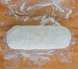 Yeast puff pastry. Photo from above. Photo of dough on a wooden board with flour. Whole grain flour dough.