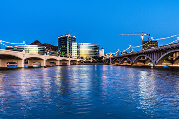 Tempe Town Lake is crossed by bridges illuminated at dusk